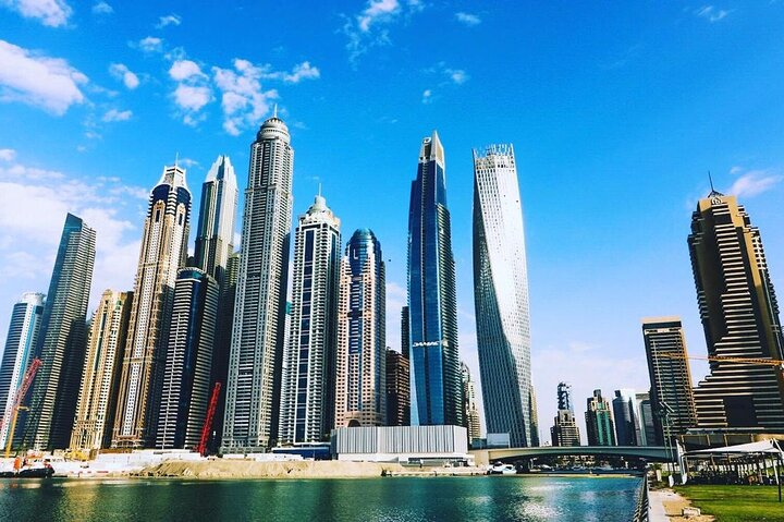 Explore Dubai's architectural wonders as you gaze upon the stunning skyline where modern skyscrapers rise majestically over serene waters showcasing the city’s grandeur and innovation.